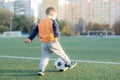 A little boy plays soccer in a city Park gives a pass kicks a ball Royalty Free Stock Photo