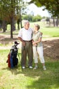 My partner in life and ... golf. A happily married senior couple standing together and smiling during a game of golf. Royalty Free Stock Photo