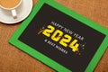 Happy New Year post on slate with cup of team. 2024 celebration theme poster