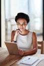 My tablet helps me schedule my business day. Portrait of a smiling young businesswoman using a digital tablet in an Royalty Free Stock Photo