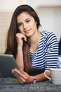 My tablet keeps me connected wherever I am. Portrait of a smiling young woman lying on the floor at home using a digital