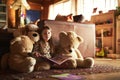 My teddy bears love storytime as much as I do. a little girl reading a book with her teddy bears around her. Royalty Free Stock Photo