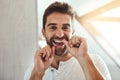 My teeth makes a great smile. Cropped portrait of a handsome young man flossing his teeth in the mirror at home. Royalty Free Stock Photo