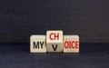 My voice choice symbol. Businessman turns wooden cubes and changes the concept word My choice to My voice. Beautiful black table