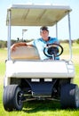 On my way to the next hole. A mature man driving a golf cart across the course. Royalty Free Stock Photo