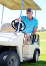 On my way to the next hole. A mature man driving a golf cart across the course. Royalty Free Stock Photo