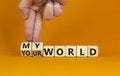 My or your world symbol. Businessman turns wooden cubes and changes words `your world` to `my world`. Beautiful orange table,