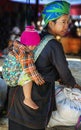 Tribal woman and her child selling in her back in local market, Myanmar