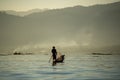 Myanmar men rowing boats using legs Came out to fish in the morning with fog and smoke Royalty Free Stock Photo