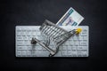 Myanmar money, White computer keyboard, Miniature shopping cart, Black background, Online shopping concept in stores, Low prices Royalty Free Stock Photo