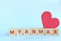 Myanmar word on wooden blocks with red heart shape cutout in blue background. Support, sympathy pray, and send love to Myanmar