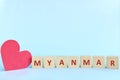 Myanmar word on wooden blocks with red heart shape cutout in blue background. Support, sympathy pray, and send love to Myanmar