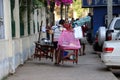 Myanmese male street vendor carry on a shoulder pole of belongings to sell products at the market