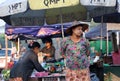 Myanmese woman with thanakha Myanmar powder on her face and wearing conical hat standing in the market