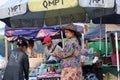 Myanmese woman with thanakha Myanmar powder on her face and wearing conical hat standing in the market