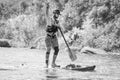 Myhiya, Ukraine - August 17, 2019: Sportsman paddling whitewater river on a inflatable stand up paddle board SUP