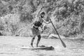 Myhiya, Ukraine - August 17, 2019: Sportsman paddling whitewater river on a inflatable stand up paddle board SUP