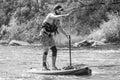 Myhiya, Ukraine - August 17, 2019: Sportsman paddling whitewater river on a inflatable stand up paddle board SUP