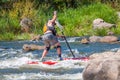 Myhiya, Ukraine - August 17, 2019: Sportsman paddling whitewater river on a inflatable stand up paddle board SUP