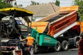 MYKOLAIV, UKRAINE - AUGUST 04, 2021: Worker with road repair machinery laying new asphalt