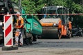 MYKOLAIV, UKRAINE - AUGUST 04, 2021: Workers with road repair machinery laying new asphalt