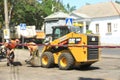 MYKOLAIV, UKRAINE - AUGUST 04, 2021: Workers with road repair machinery laying new asphalt, focus on construction tape