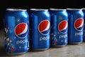 MYKOLAIV, UKRAINE - FEBRUARY 9, 2021: Many cans of Pepsi on table against black background