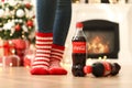 MYKOLAIV, UKRAINE - JANUARY 15, 2021: Woman near Coca-Cola bottles in room decorated for Christmas, closeup