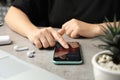 MYKOLAIV, UKRAINE - JULY 9, 2020: Woman entering passcode on Iphone 11 at table, closeup