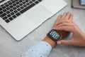 MYKOLAIV, UKRAINE - SEPTEMBER 19, 2019: Woman using Apple Watch at grey table, closeup Royalty Free Stock Photo