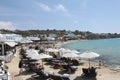 Mykonos beach during summer with umbrella and luxury beach chairs beds, blue ocean with mountain at Elia beach Mikonos Greece
