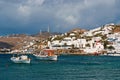 Mykonos, Greece - May 04, 2010: Fishing village at seaside on cloudy sky. Houses at sea coast. Boats in blue sea on