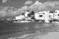 Mykonos, Greece - May 04, 2010: sea beach on cloudy blue sky. Village at sea coast. Church and houses at seaside. Summer