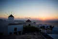 Mykonos, Greece. Sunset over the sea with iconic windmills of the Greek island of the Mikonos, seen from terrace Royalty Free Stock Photo