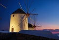 Mykonos, Greece. Traditional windmills. The symbol of Mykonos during sunset. Landscape during sunset. Sea shore and beach.