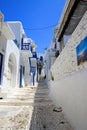 Quaint old town of Mykonos with bright blue sky against clean white houses with brightly painted balconies and doors..