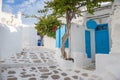 Mykonos streetview with blue door and trees, Greece