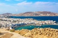 Mykonos town port with red churches, famous windmills, ships and yachts during summer sunny day. Aegean sea, Greece