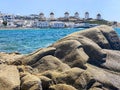 Mykonos windmills in a row, rocks on beach on foreground, Greece Royalty Free Stock Photo
