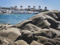 Mykonos windmills, rocks on beach on foreground, Greece