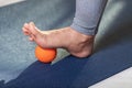 Myofascial relaxation of hyper-movable muscles of the foot, with a massage ball on a gymnastic mat, close-up Royalty Free Stock Photo