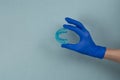 Myofunctional trainer for correction of bite and alignment of teeth in the hand of doctor in the glove on blue background