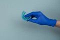 Myofunctional trainer for correction of bite and alignment of teeth in the hand of doctor in the glove on blue background