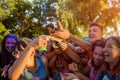 Myrhorod, Ukraine - June 16, 2019: Group of a young friends throwing paints on indian Holi festival of colors