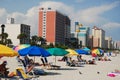 Umbrellas and tourists on the coast Royalty Free Stock Photo