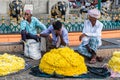 Indian flower vendors at their shop selling flowers at the Devaraja market in the city of