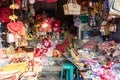 An Indian woman shopkeeper in a store selling cheap leather bags, stuffed toys and