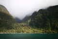 Mysterial island in misty sky with mountains, lush vegetation and patches of sunlight