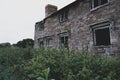 A mysterious, abandoned, ruined home. With empty window frames and entrance blocked by plants