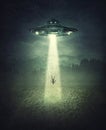 Mysterious alien spaceship abduction scene. Surreal concept with a levitating human stolen by the light of an UFO ship in a dark